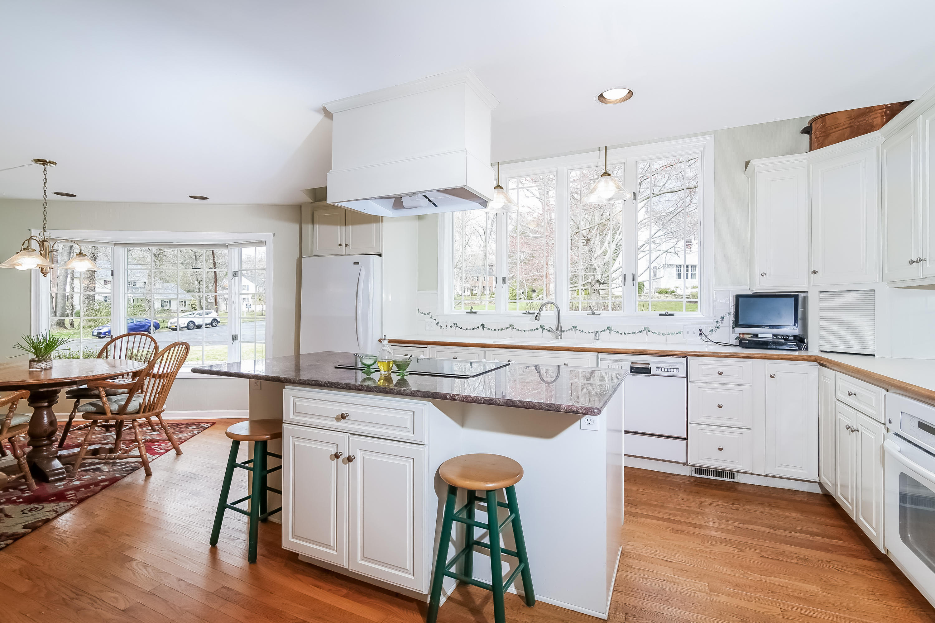 101 Colony Road Darien, CT 06820 - Photo 7 of 31 a large kitchen with kitchen island a large window a sink and white appliances