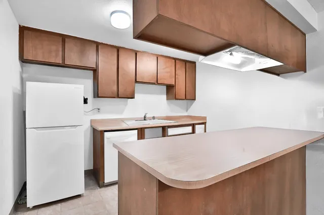 a kitchen with stainless steel appliances a refrigerator a sink a stove and white cabinets