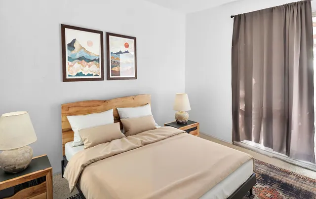 a bed room with a bed and a painting on the wall