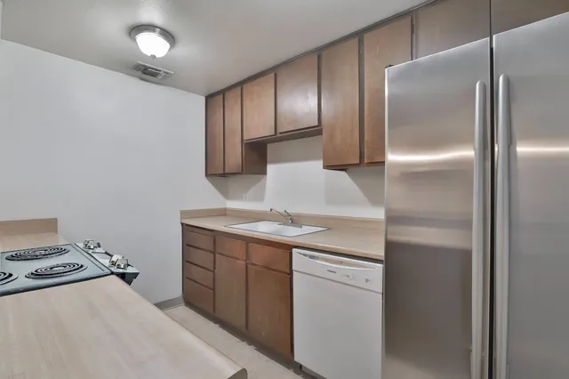 a kitchen with a refrigerator and white cabinets
