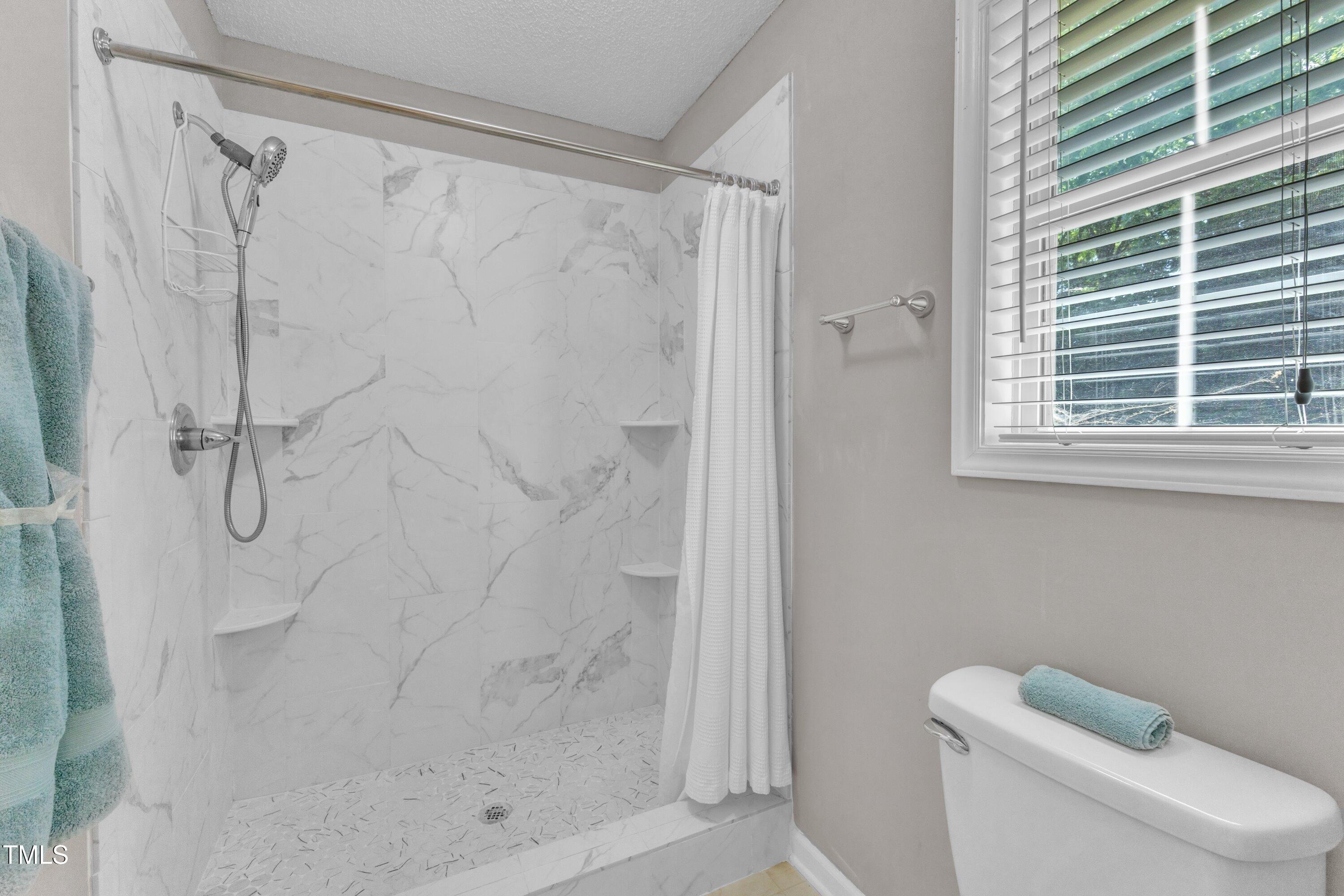 4533 Whistling Way Raleigh, NC 27616 - Photo 22 of 25 a bathroom with a shower and a toilet