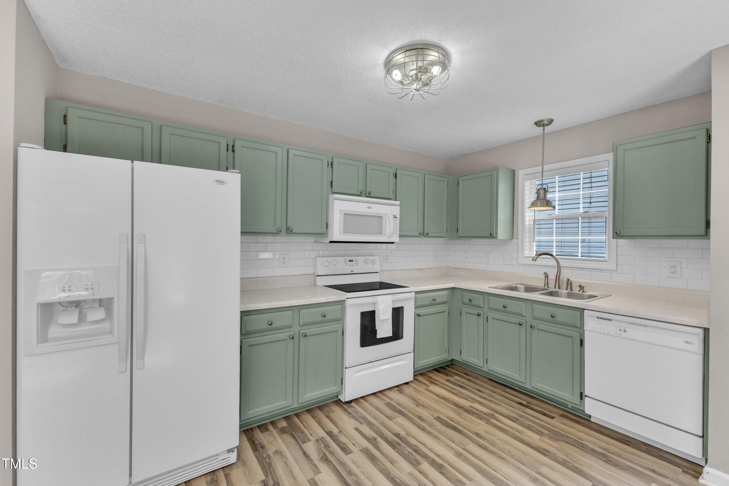 4533 Whistling Way Raleigh, NC 27616 - Photo 10 of 25 a kitchen with a sink a refrigerator and a stove