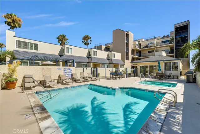 a view of a patio with couches and table and chairs with wooden floor and fence