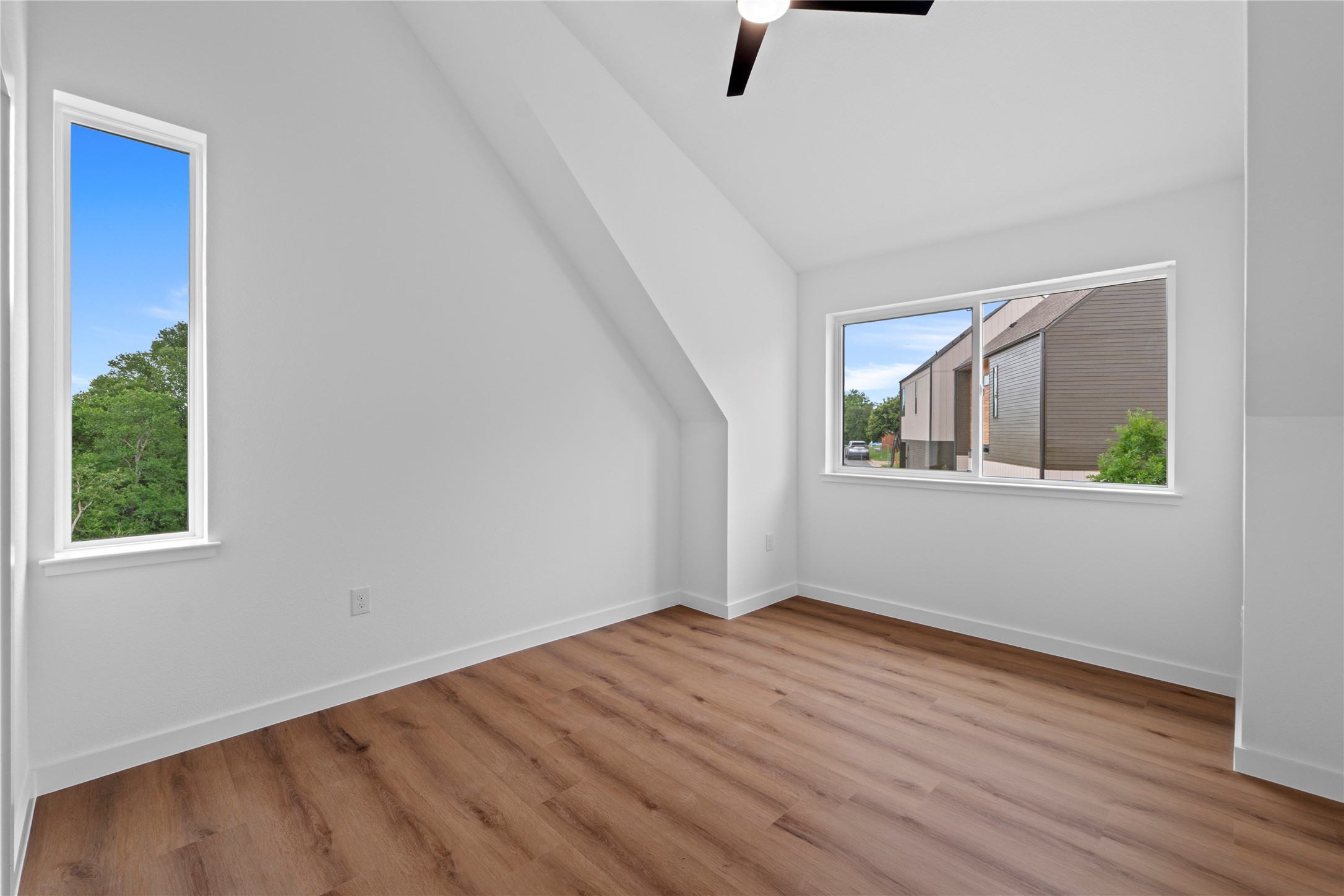 1406 Mason Avenue Austin, TX 78721 - Photo 9 of 36 MODEL HOME - REPRESENTATIVE PHOTO: Spacious interior with wood-finish flooring, crisp white walls, and a contemporary ceiling fan