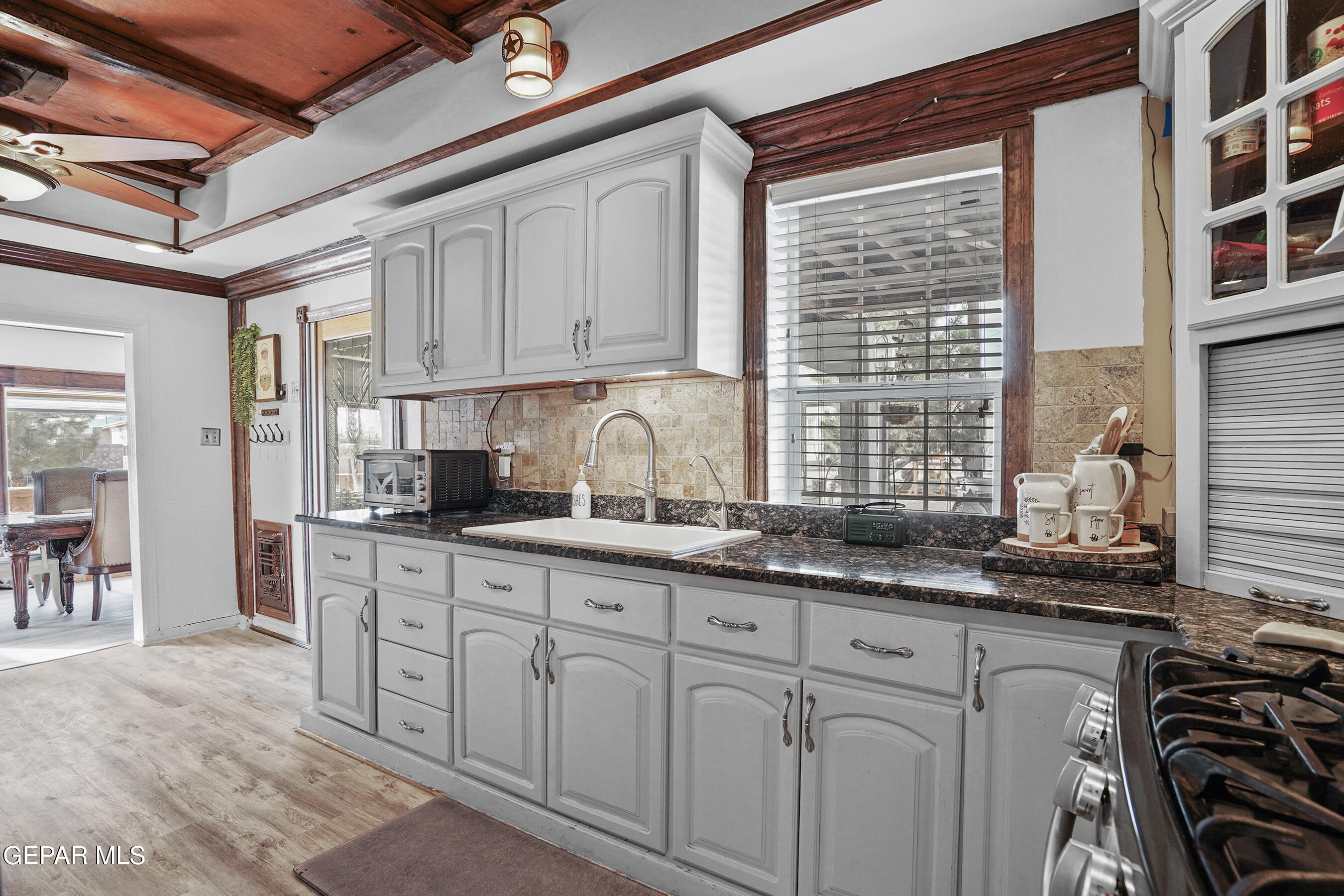 146 Croom Road El Paso, TX 79915 - Photo 2 of 54 a kitchen with granite countertop a sink and a white wooden cabinets