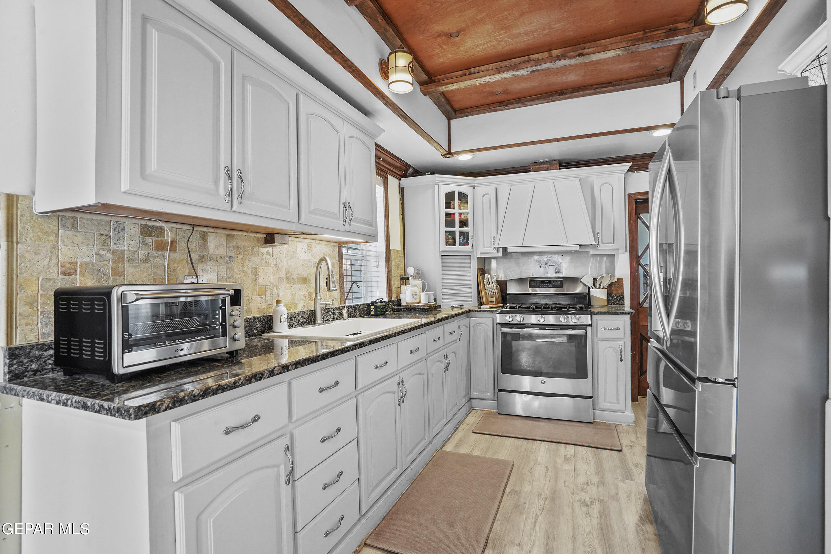 146 Croom Road El Paso, TX 79915 - Photo 5 of 54 a kitchen with granite countertop white cabinets and stainless steel appliances
