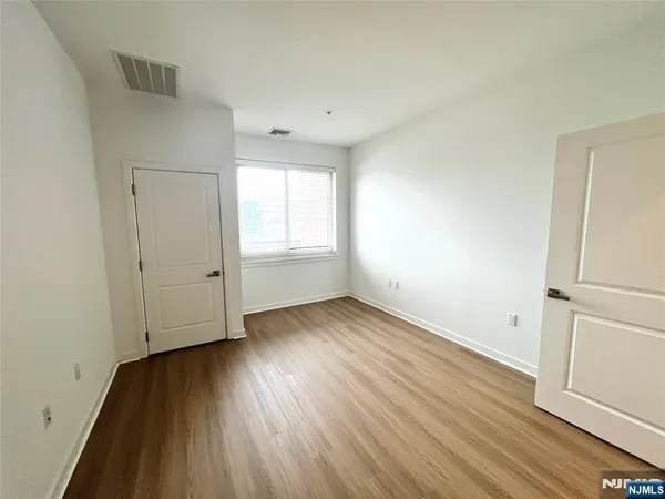 an empty room with wooden floor and window
