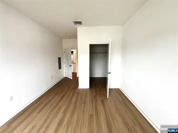 a view of empty room with wooden floor