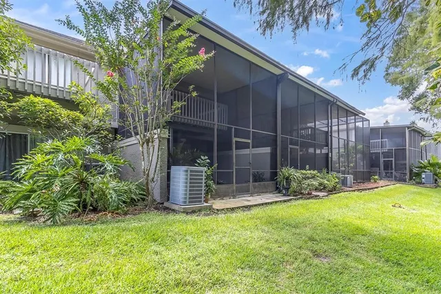 a backyard of a house with table and chairs and potted plants