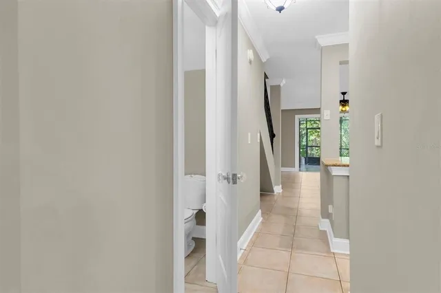a view of a hallway with wooden floor and a bathroom