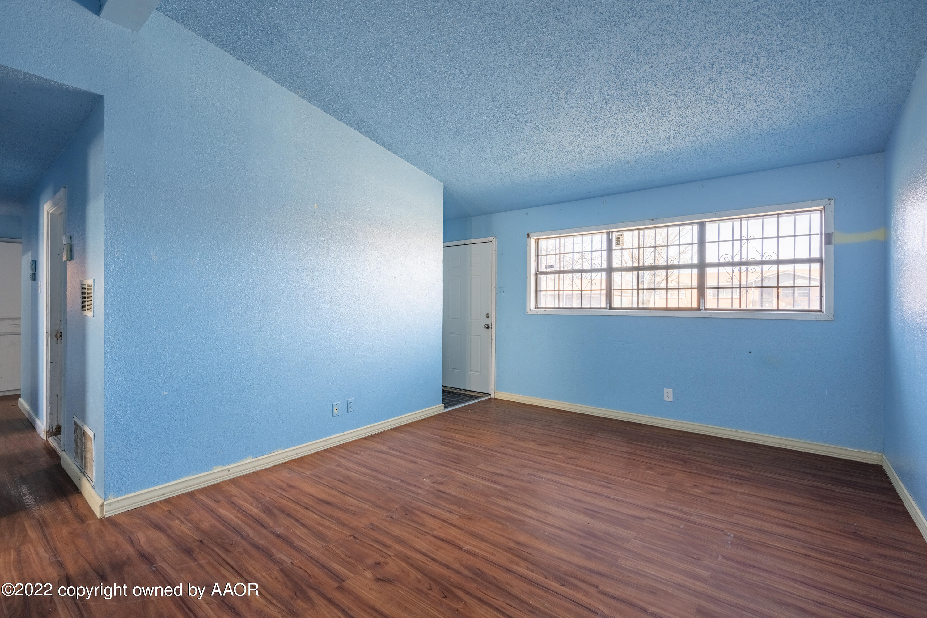 920 Heather Street Amarillo, TX 79107 - Photo 6 of 23 an empty room with wooden floor and windows