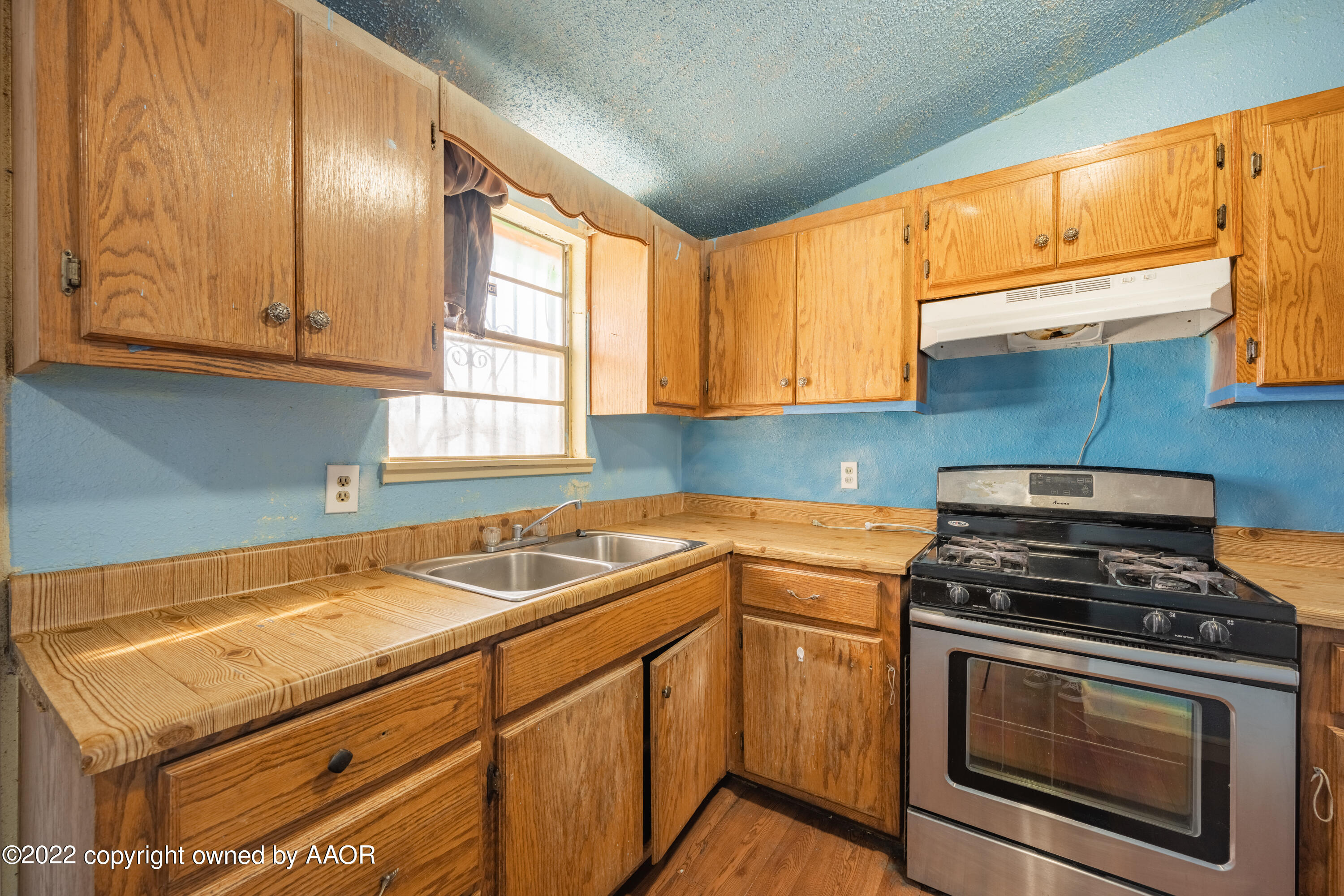 920 Heather Street Amarillo, TX 79107 - Photo 9 of 23 a kitchen with granite countertop a sink stainless steel appliances wooden cabinets and a window