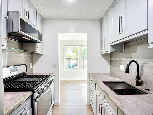 a kitchen with stainless steel appliances a stove a microwave and cabinets