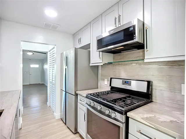 a kitchen with stainless steel appliances granite countertop a sink stove and refrigerator