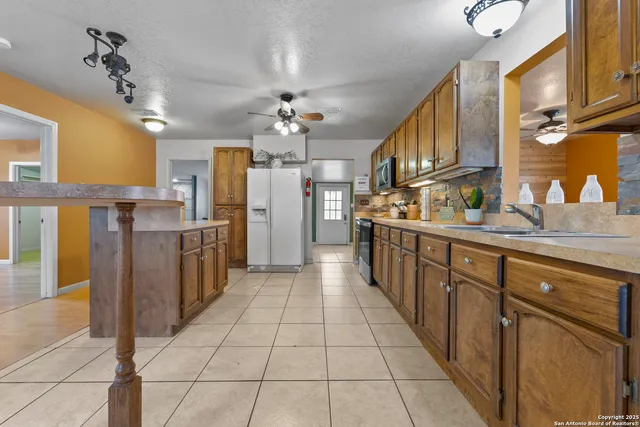a kitchen with stainless steel appliances granite countertop a refrigerator and a stove top oven