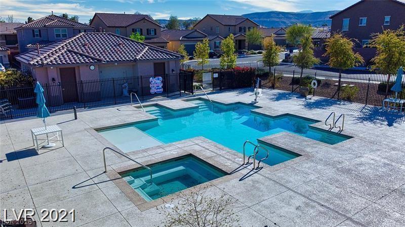 5475 Ordesa Valley Road Las Vegas, NV 89148 - Photo 4 of 35 An inviting community pool complex awaits, framed by residential homes and distant hills.