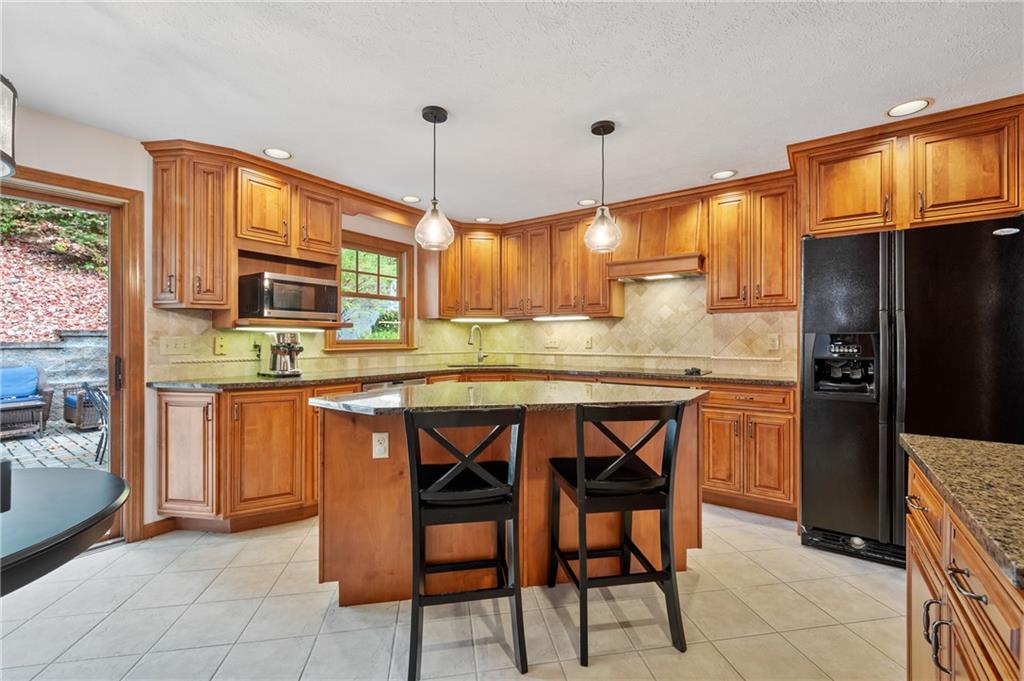 122 Rippling Brook Drive Sewickley, PA 15143 - Photo 5 of 31 a kitchen with stainless steel appliances granite countertop wooden cabinets a stove top oven a sink and dishwasher