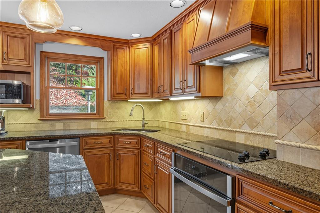 122 Rippling Brook Drive Sewickley, PA 15143 - Photo 7 of 31 a kitchen with stainless steel appliances granite countertop a sink and cabinets