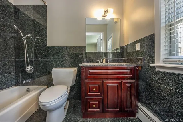 a bathroom with a sink a toilet a mirror and bathtub