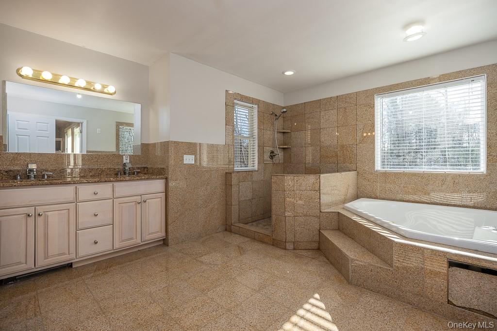 85 York Road Bloomingburg, NY 12721 - Photo 32 of 32 a spacious bathroom with a granite countertop tub sink a mirror a shower and vanity