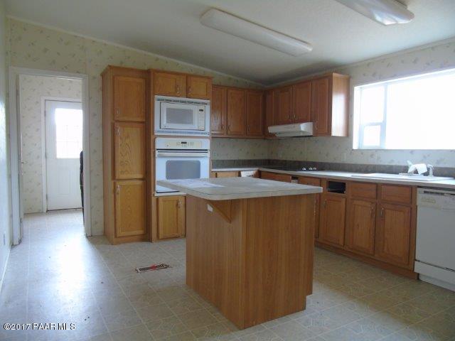 2480 East View Ridge Road Rimrock, AZ 86335 - Photo 7 of 20 a kitchen with stainless steel appliances granite countertop a refrigerator a sink dishwasher a stove and a microwave oven on the blue kitchen countertops with wooden floor