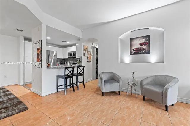a living room with furniture and kitchen view
