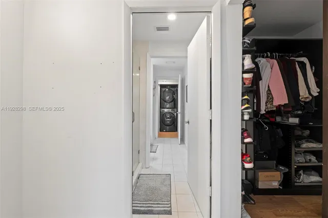 a view of walk in closet with clothes and shoes