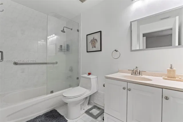 a bathroom with a toilet sink vanity tub and shower