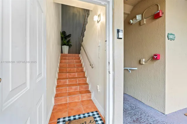 a view of a hallway with wooden floor and cabinet