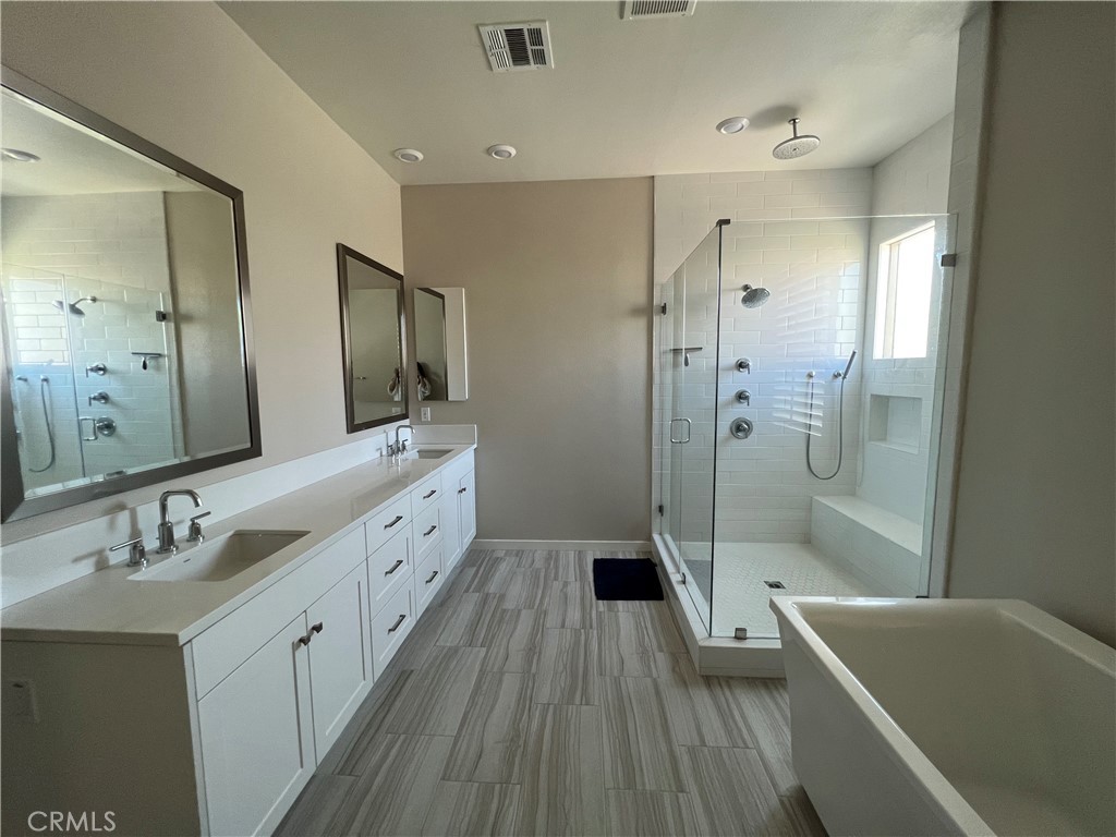 110 Sculpture Irvine, CA 92618 - Photo 22 of 37 a spacious bathroom with a tub sink shower and mirror