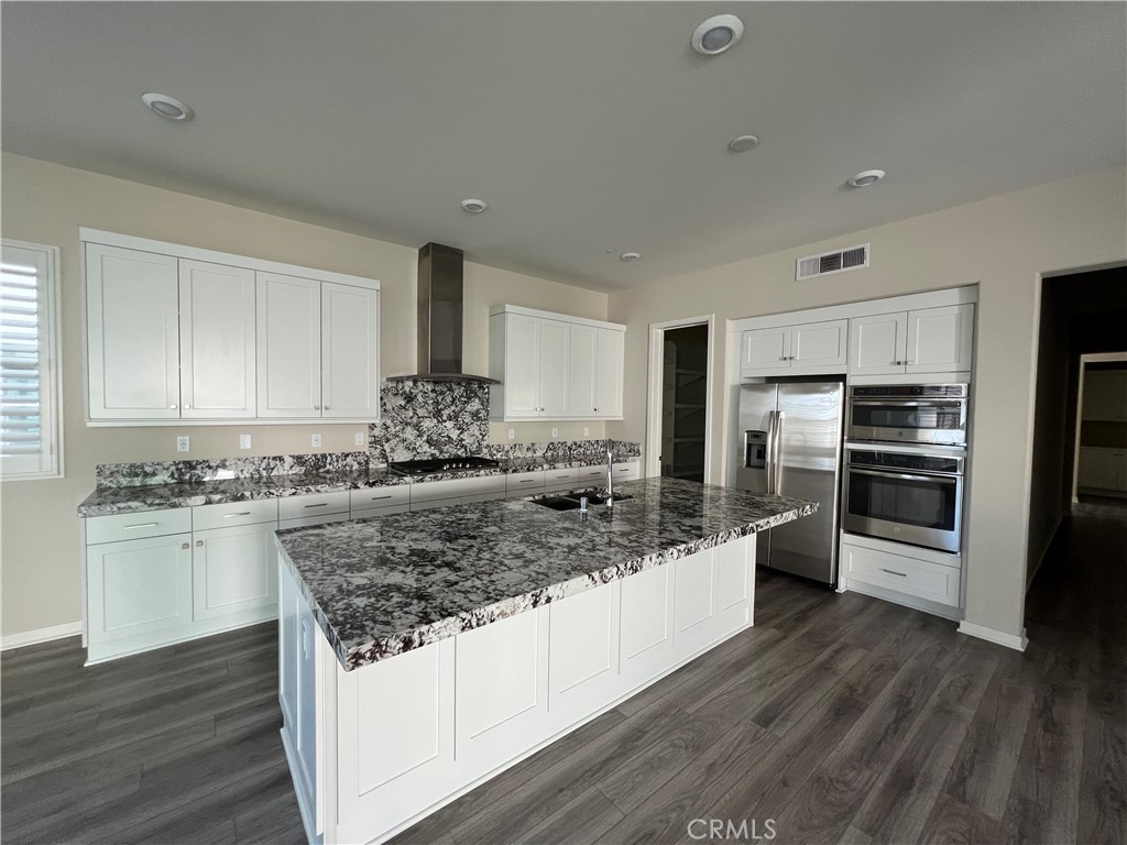 110 Sculpture Irvine, CA 92618 - Photo 6 of 37 a kitchen with a center island wooden floor and stainless steel appliances