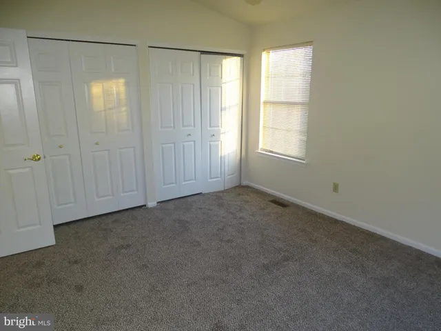 an empty room with windows and closet