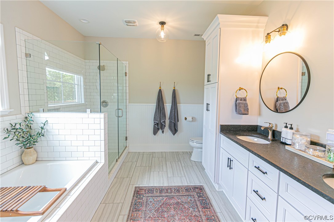 10337 Georgetown Road Mechanicsville, VA 23116 - Photo 28 of 50 Luxury Primary Full bathroom featuring tile flooring, natural light, toilet, separate shower and tub enclosures, dual bowl vanity, and dual mirrors