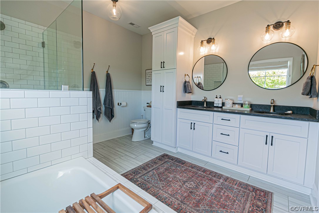 10337 Georgetown Road Mechanicsville, VA 23116 - Photo 30 of 50 Full bathroom featuring tile flooring, toilet, double sink vanity, separate shower and tub enclosures, and mirror