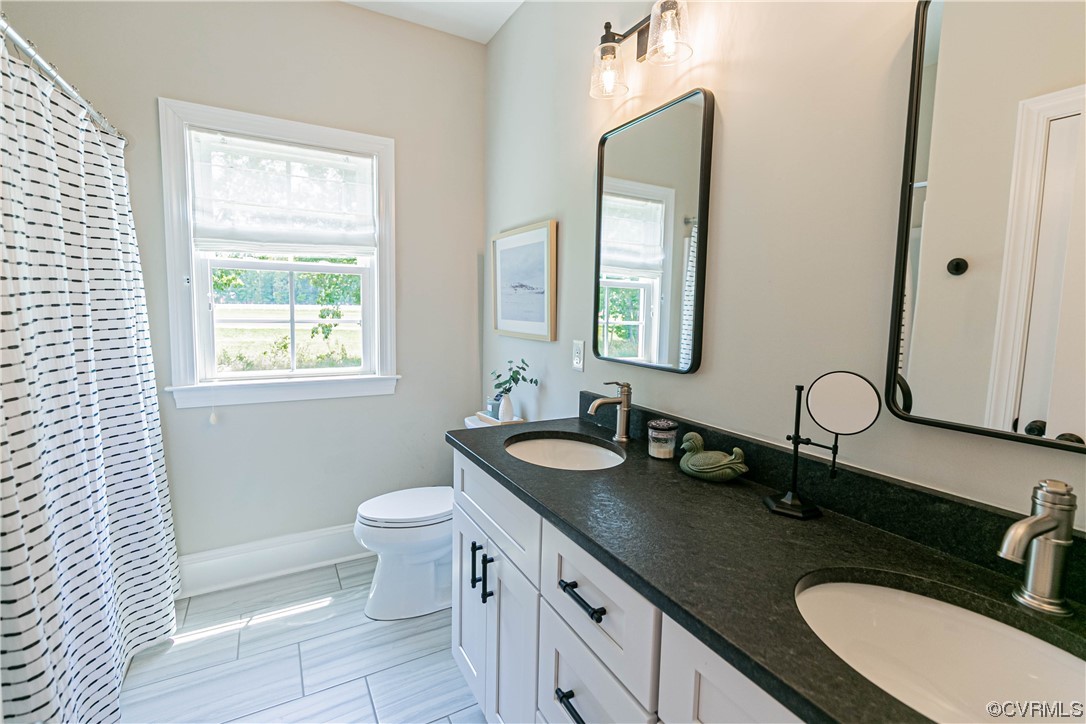 10337 Georgetown Road Mechanicsville, VA 23116 - Photo 34 of 50 Bathroom featuring tile flooring, natural light, double sink vanity, mirror, tub/shower unit and toilet!