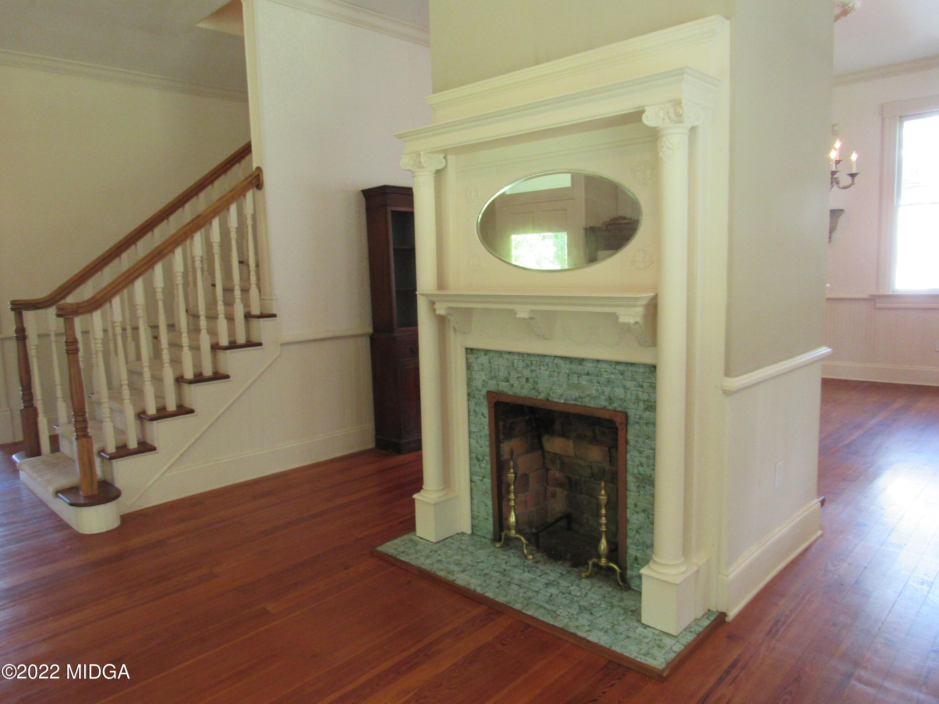 6999 South Rogers Road Macon, GA 31216 - Photo 27 of 61 a view of livingroom with fireplace wooden floor and staircase