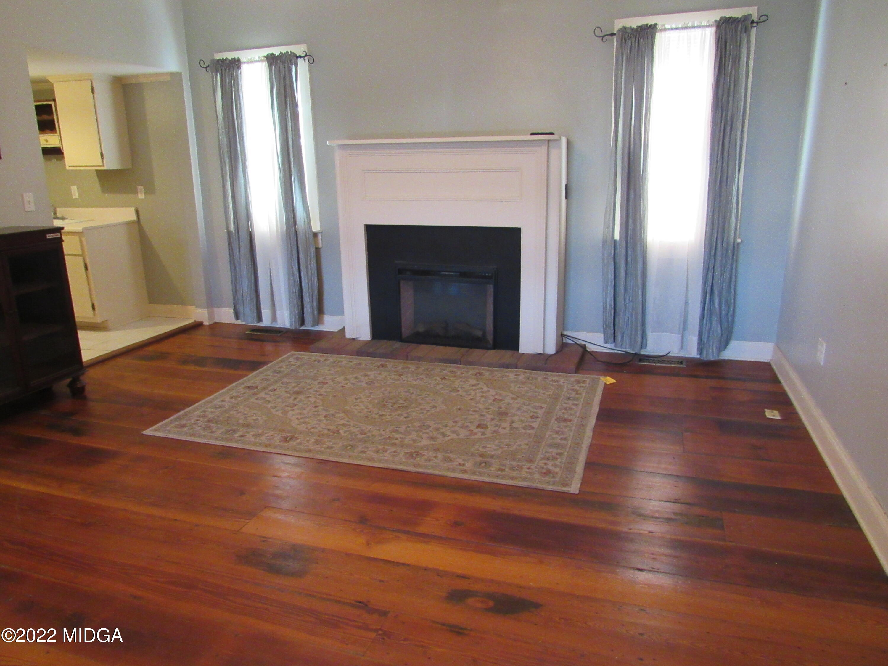 6999 South Rogers Road Macon, GA 31216 - Photo 34 of 61 an empty room with wooden floor and fireplace