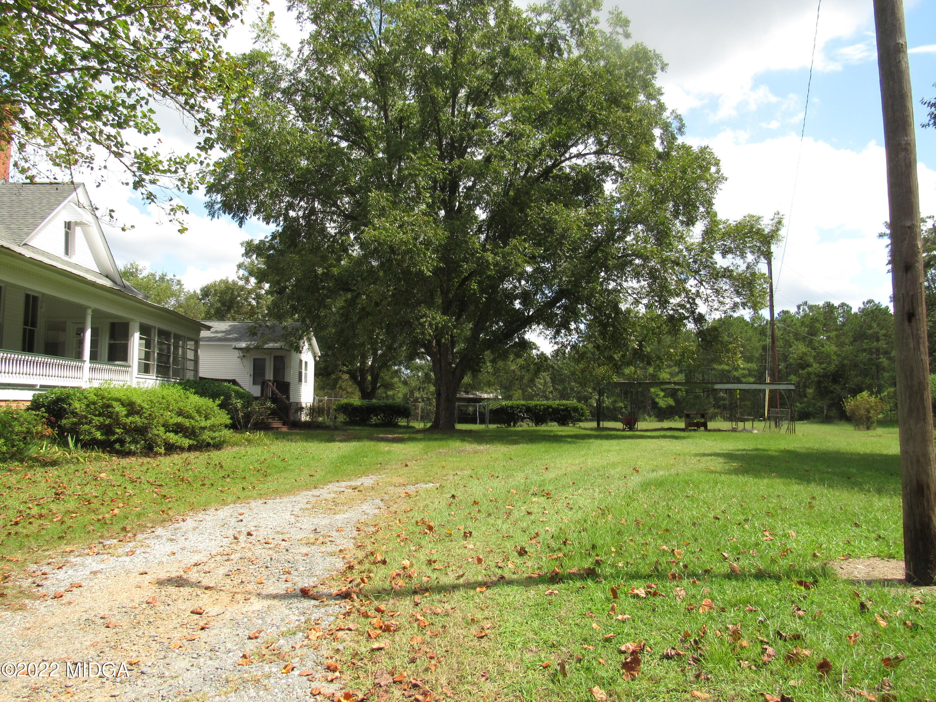 6999 South Rogers Road Macon, GA 31216 - Photo 5 of 61 a view of a house with a big yard and large trees