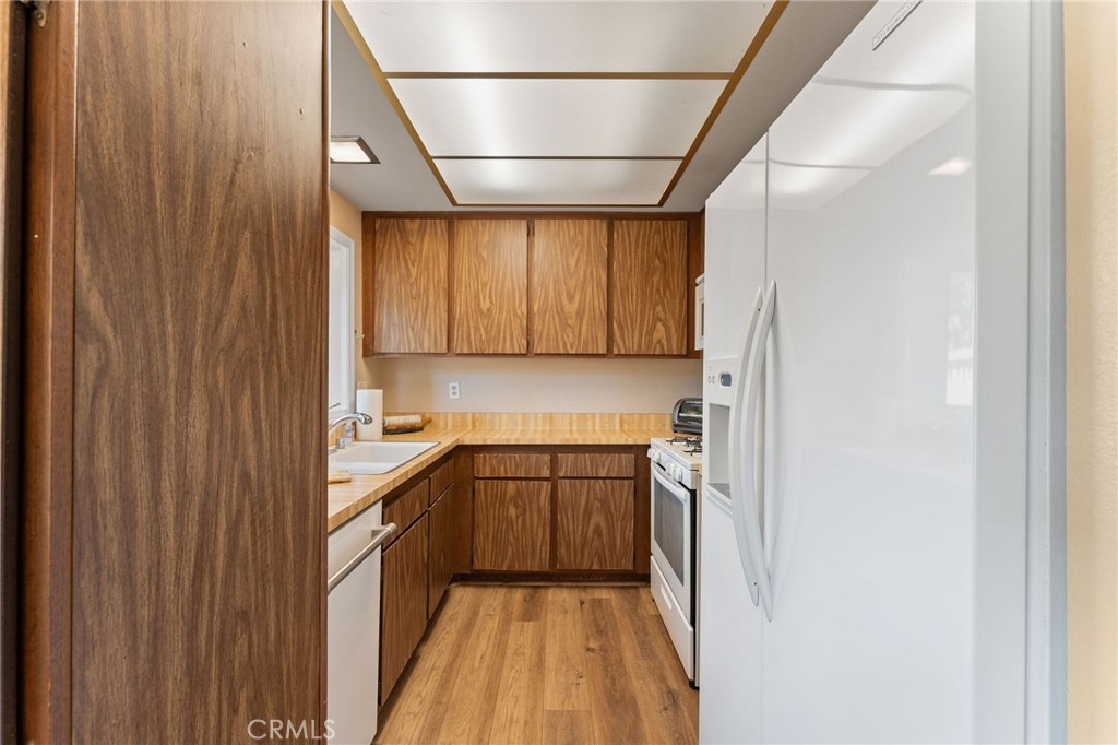 92 Orchard Irvine, CA 92618 - Photo 14 of 46 a kitchen with a sink a refrigerator and cabinets