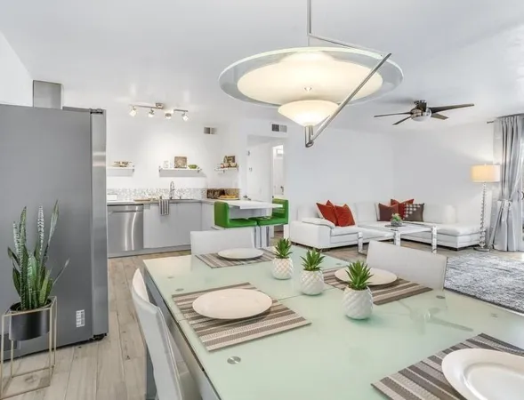 a dining room with furniture a kitchen view and a chandelier