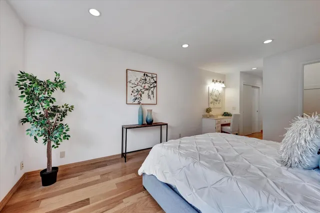 a bedroom with a bed and a table with potted plants