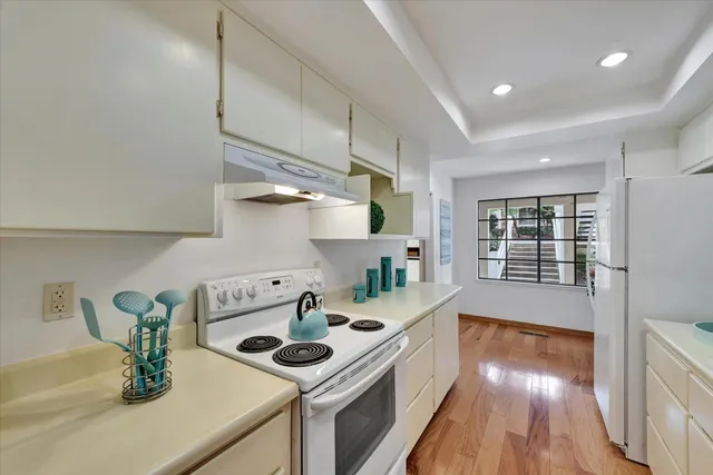 a kitchen that has a sink cabinets counter space and appliances