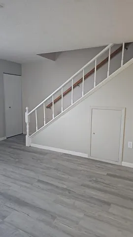 a view of an empty room with wooden floor