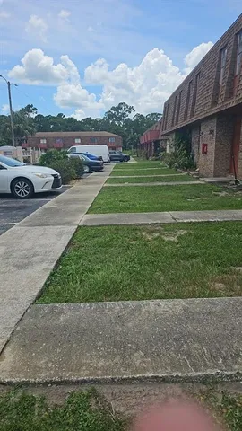 a view of a street with a house in the background