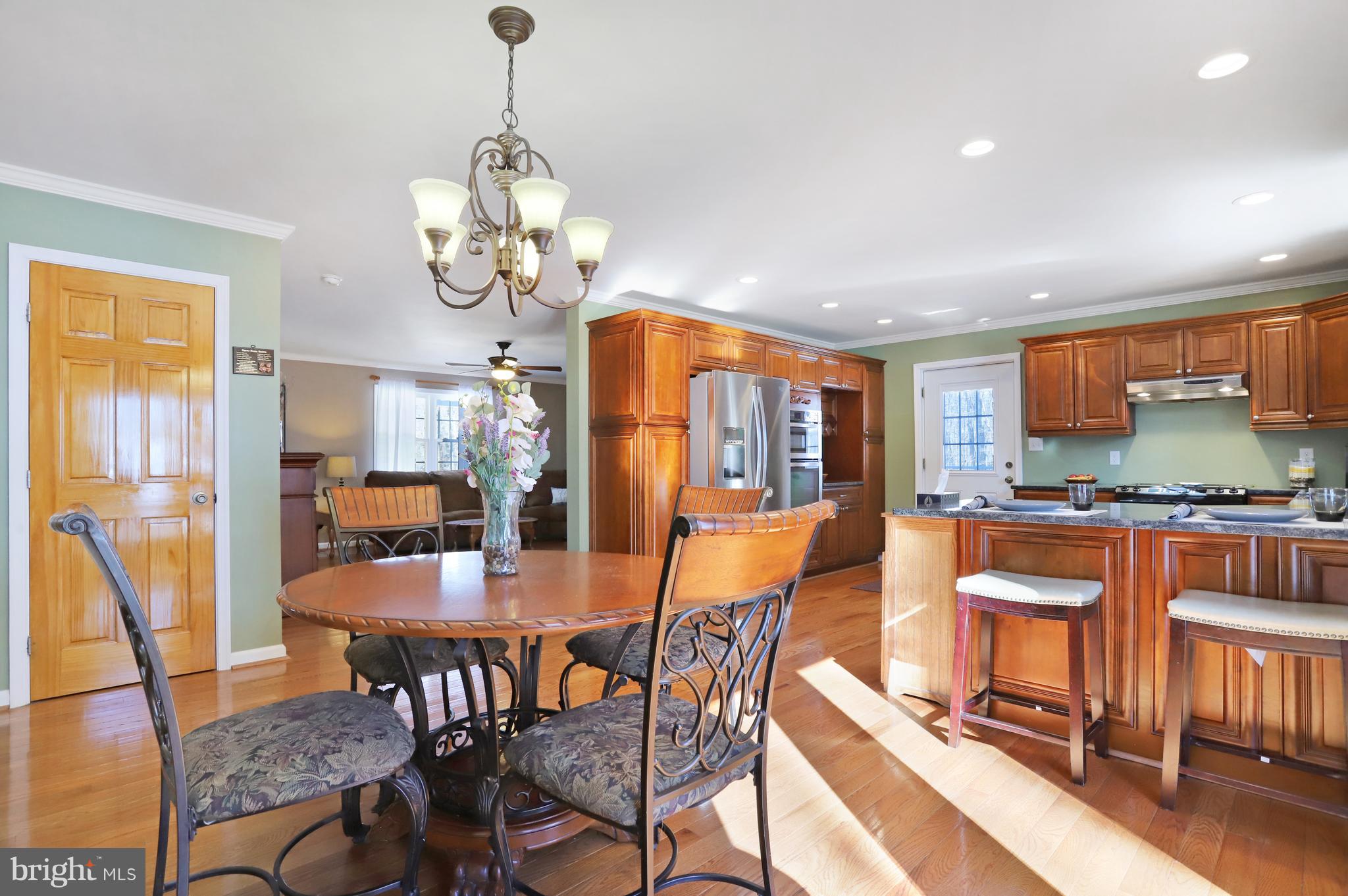 12315 Forrest Hill Road Clear Spring, MD 21722 - Photo 8 of 37 a dining room with wooden floor a chandelier a wooden table and chairs