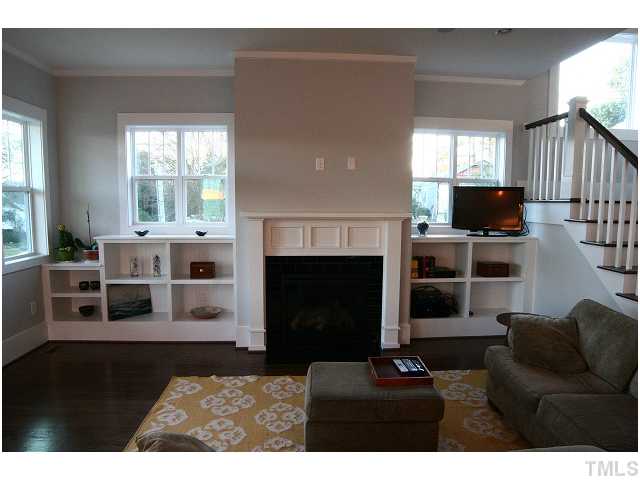 315 Georgetown Road, Unit H Raleigh, NC 27608 - Photo 4 of 20 a living room with furniture a flat screen tv and a fireplace