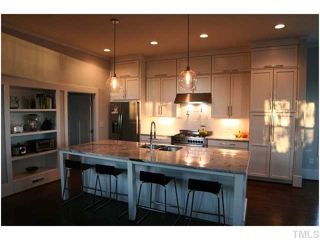 315 Georgetown Road, Unit H Raleigh, NC 27608 - Photo 7 of 20 a kitchen with kitchen island granite countertop a sink cabinets and stainless steel appliances