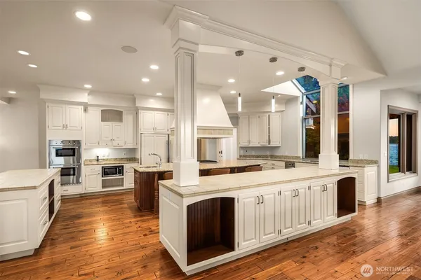 a large kitchen with stainless steel appliances lots of counter space and wooden floor