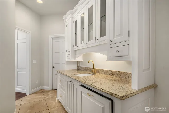 a kitchen with granite countertop a sink and cabinets