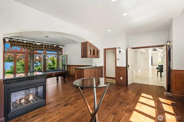 a living room with furniture a large window and wooden floor